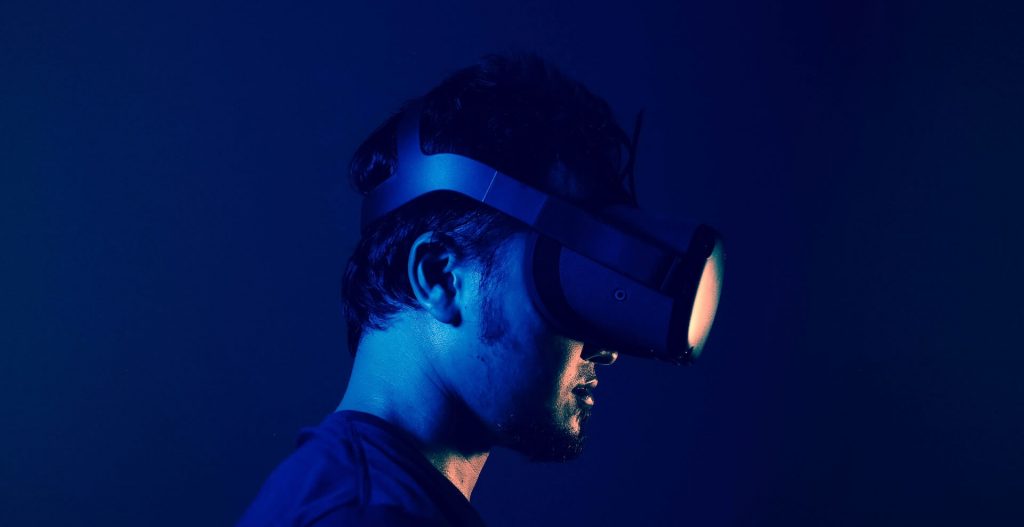 Un hombre inmerso en la realidad virtual, con un casco de RV y explorando un mundo digital