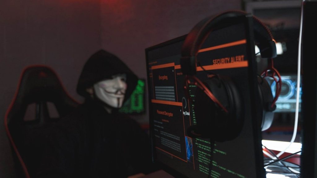 A person wearing a face mask while working at a computer
